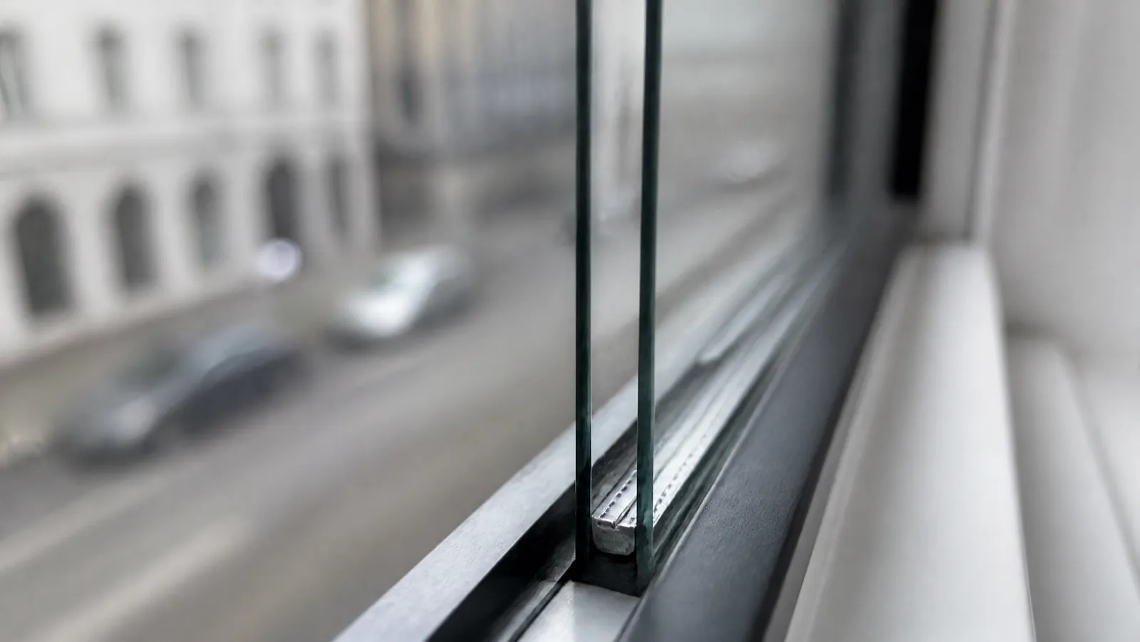 Close-up of the edge of a double-pane window unit showing both panes, the sealed air gap and the spacer bar